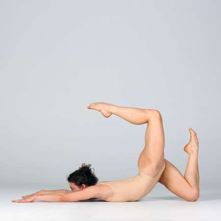 Young beautiful yoga female is exercising in studioの写真素材