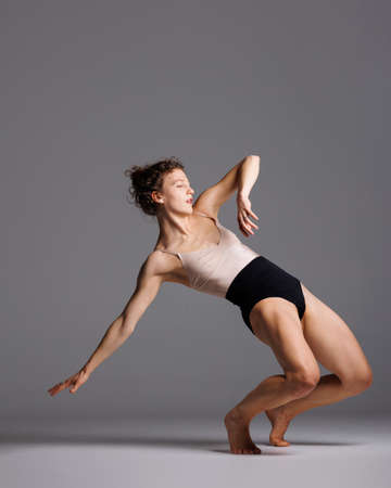 Young beautiful yoga female is exercising in studioの写真素材
