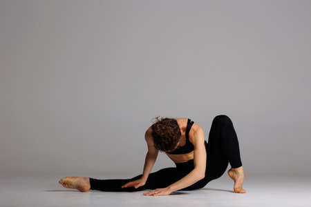 Young beautiful yoga female is exercising in studioの写真素材