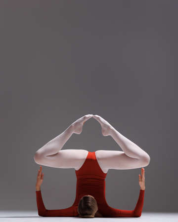 Young beautiful yoga female is exercising in studioの写真素材