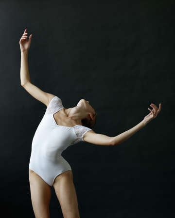 Elegant ballerina. A young graceful ballet dancer, dressed in a leotard and pointes shoes demonstrates her dance skills. Power and refinement of classical ballet.の写真素材
