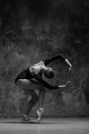 Elegant ballerina. A young graceful ballet dancer, dressed in a leotard and pointes shoes demonstrates her dance skills. Power and refinement of classical ballet.の写真素材