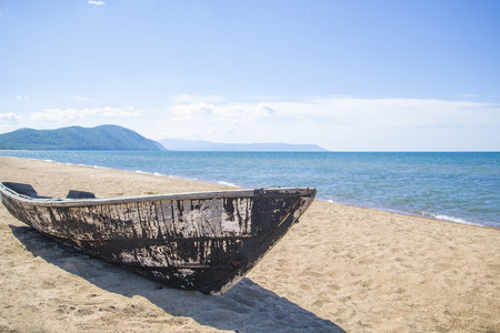Old wooden boat on the beach in a bright, Sunny, summer day.の写真素材