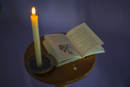 Candle, book "Alice in Wonderland" and the key are on the table.の写真素材