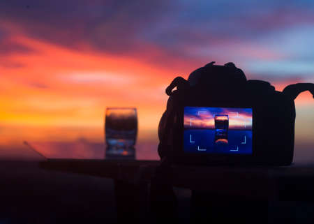 DSLR camera focusing on a water glassの写真素材