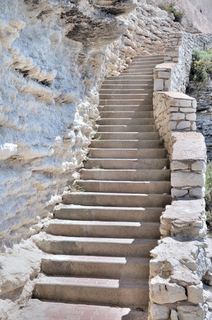 Many steps of a staircase along a limestone cliffの写真素材