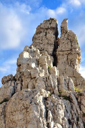 crack in a rocky peak in cloudy skyの写真素材