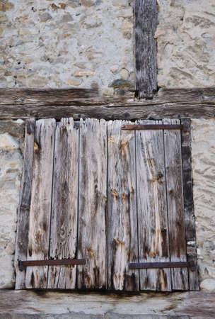 decrepit old wooden shutter on facade with a timberedの写真素材