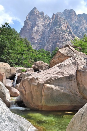 the emerald river through a rocky valley in the mountainsの写真素材