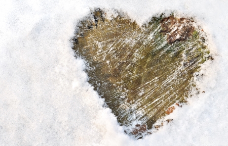 heart drawn in the snow on woodの写真素材