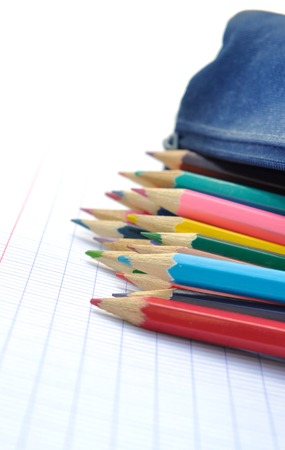 closeup of colored pencils  on a  school copy in backgroundの写真素材