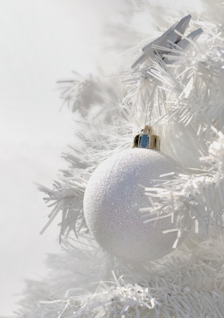 closeup of a Christmas ball on a white branch in white christmas treeの写真素材