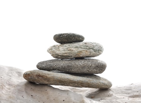 pebbles stacked on driftwood isolated on white backgroundの写真素材