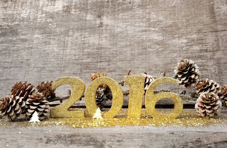 golden figures  2016 with pine cones on wooden backgroundの写真素材