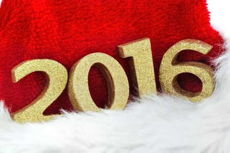 close on golden figures 2016 on a santa claus hat on white backgroundの写真素材