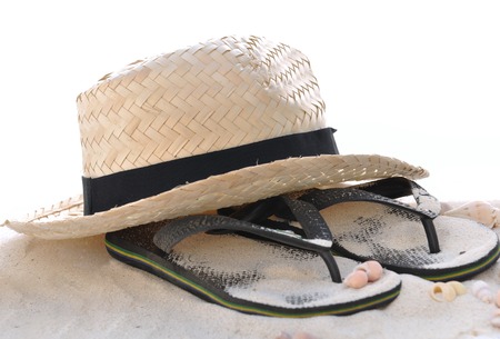 straw hat and flip flops on the sand on white backgroundの写真素材