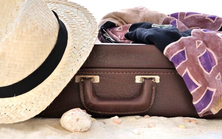 straw hat and sarong on suitcase in sand on white backgroundの写真素材