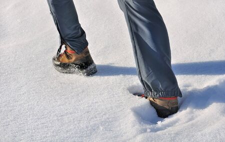 close on man's feet walking on the snow