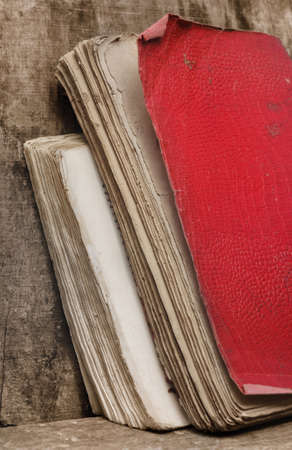 old books with red cover on wooden backgroundの写真素材