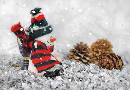 snowman figurine in bright confetti under snowfallの写真素材