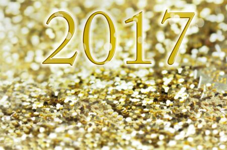 2017 written on golden and bright glitters background