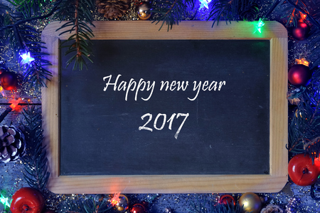 Happy new year 2017 written on a slate on Christmas decoration