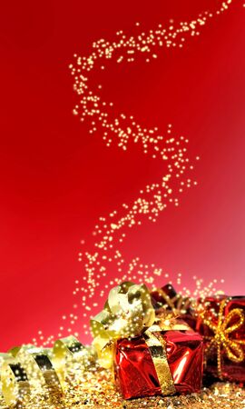 Christmas gifts in golden confetti on red backgroundの写真素材