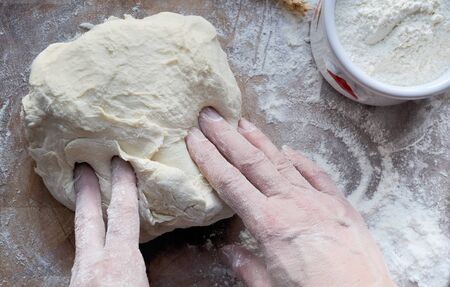 bread dough prepared bu a cook on wooden board
