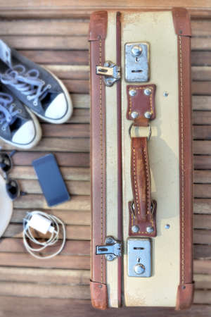top view on retro  suitcase on wooden terrace  with travel itemsの写真素材