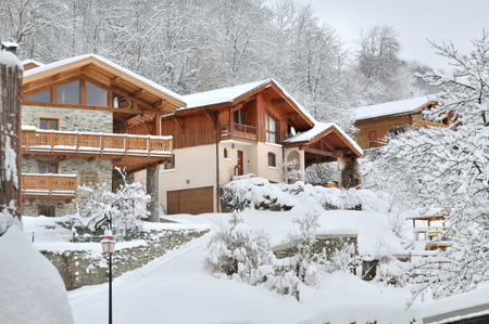 mountain  village with wooden bungalow in the snow