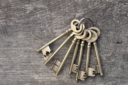 old keys in a ring on wooden background 