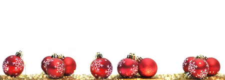 red christmas balls in golden confetti on white backgroundの写真素材