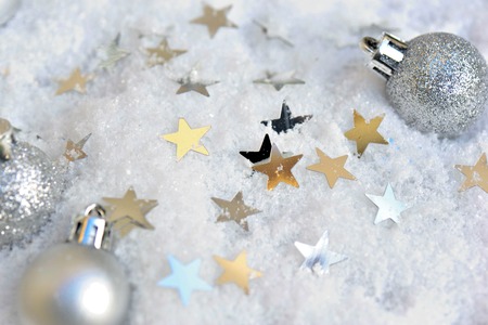 silver christmas baubles and stars in snow backgroundの写真素材