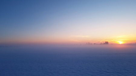 beautiful sunset in blue light in a rural landscape covered with snowの写真素材
