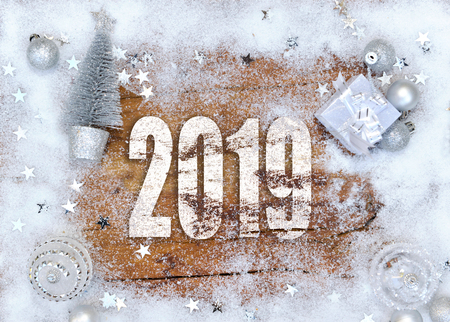 2019 new year on a plank and silver christmas decoration and stars in the snowの写真素材
