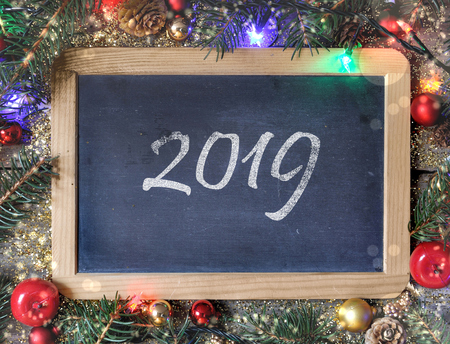 2019 written on a slate bordering with Christmas decorationの写真素材