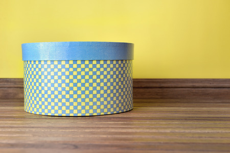 decorative hat box blue and yellow on a wooden floor indoorの写真素材