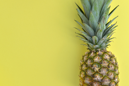 close on a fresh pinapple on yellow background with a copy space on the leftの写真素材