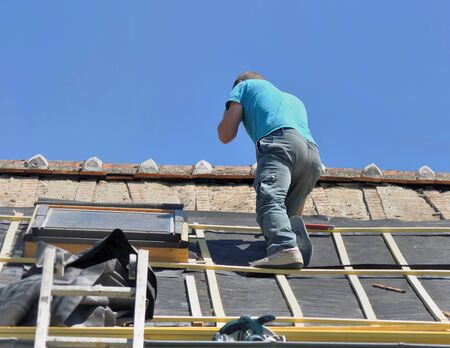 roofer on the top put a waterproof film on a roof