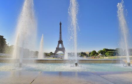 water jets in trocadero fountain on blue sky with  silhouette of eiffel tower