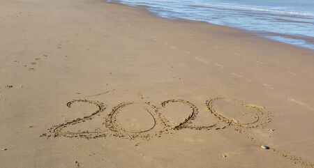 2020 written on the sand to the beach