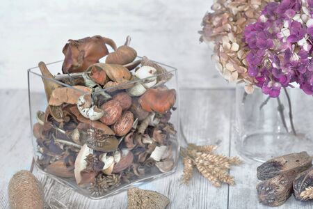 potpourri in a glass jar and dried flower on a table の写真素材
