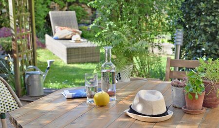 close on drink and apple on a wooden table in garden  background in summer