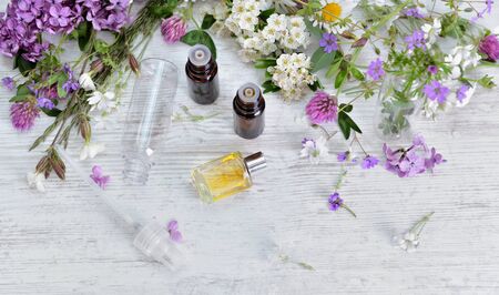 essential oil bottles and freshness  flowers  on  a white table