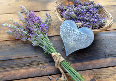 decorative metal heart among flowers of lavender on wooden backgroundの写真素材