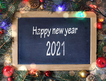 happy new year 2021 writing on a slate in christmas ornamentの写真素材