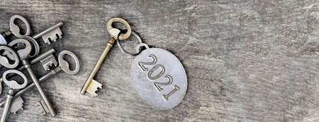 2021 engraved on a ring of an old key on wooden backgroundの写真素材