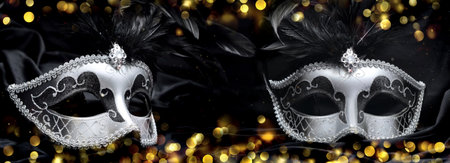 beautiful two venitian carnival masks on dark fabric and blur lights backgroundの写真素材