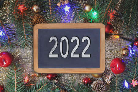 2022 written on a slate in  Christmas ornament background