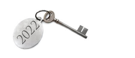 2022 engraved on a ring of an old key on white background